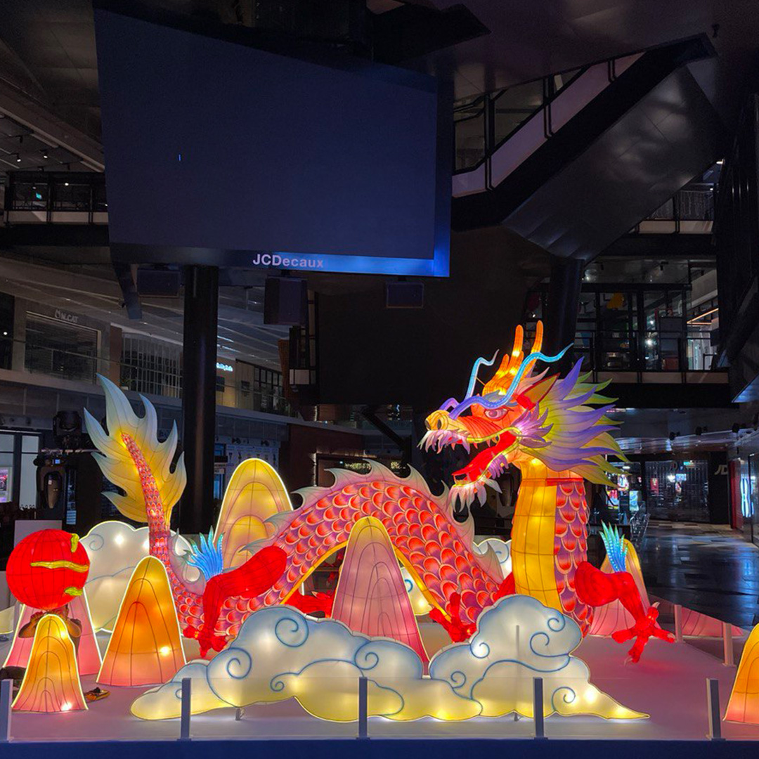 Large-scale Chinese New Year dragon installation created through custom event fabrication for commercial mall decoration.